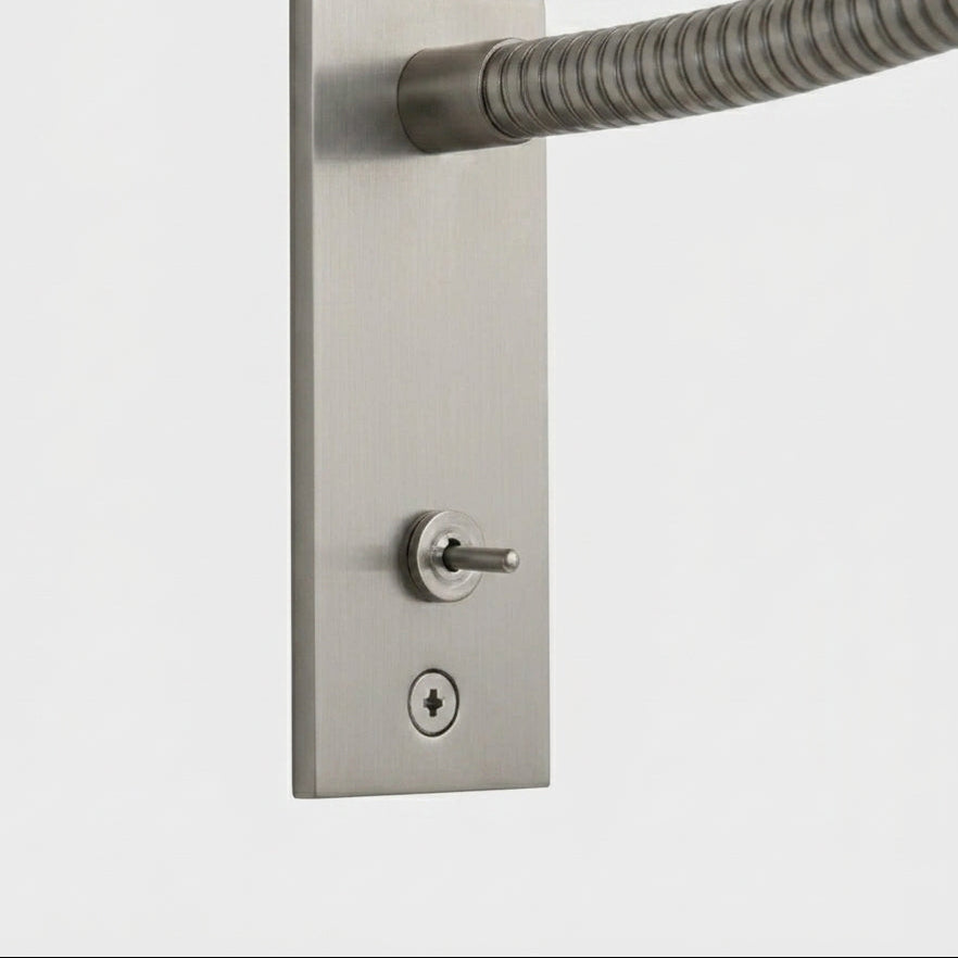 Close-up of the Hulzi nickel wall light's mounting plate and on/off switch