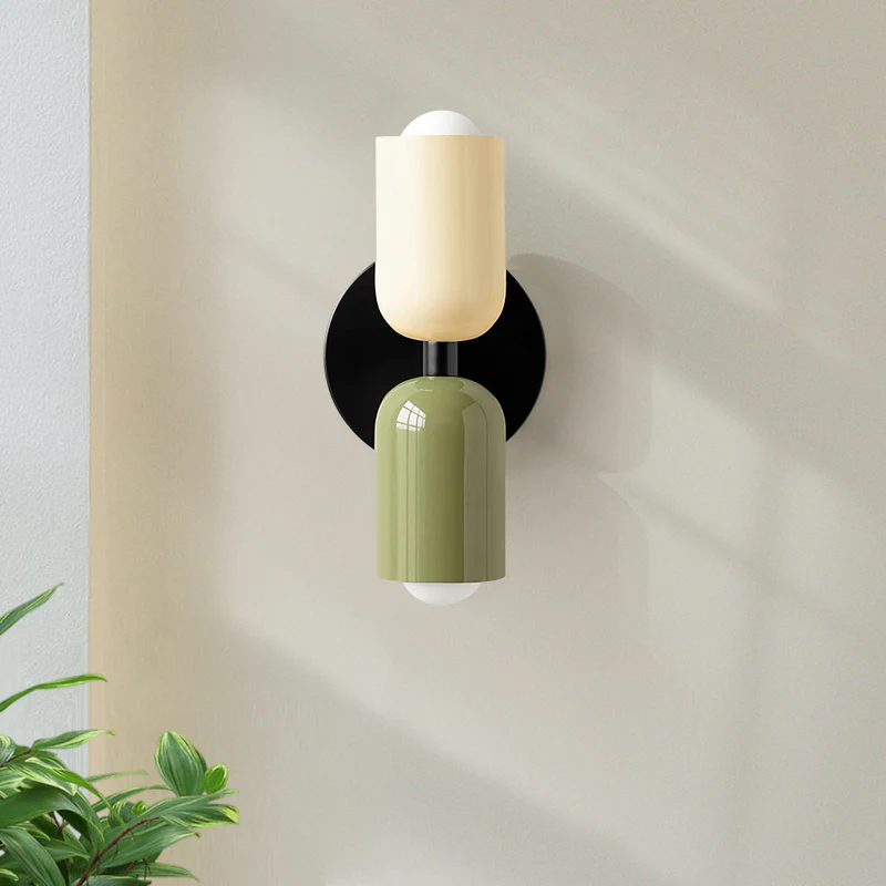 Illuminated hutre double-head capsule wall sconce casting a warm wash of light upwards and downwards