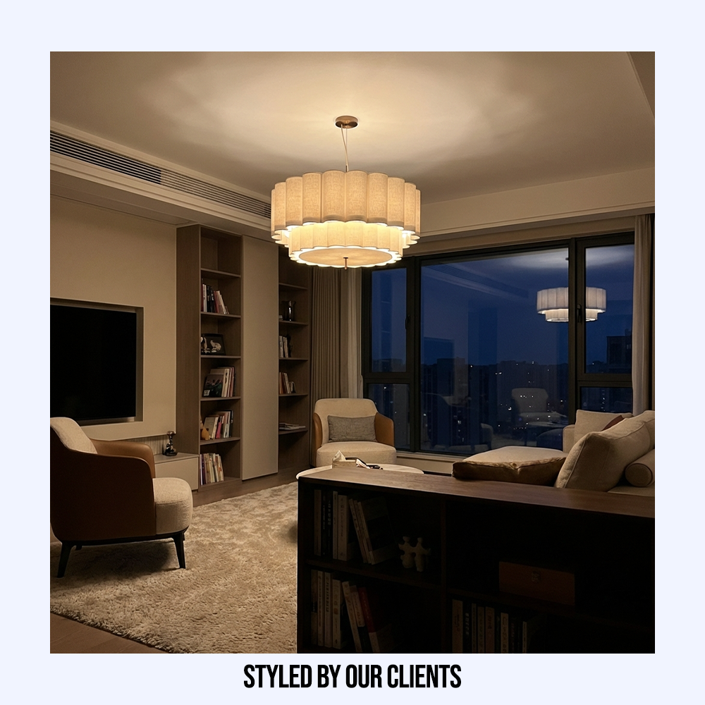 Illuminated tiered fabric chandelier casting a warm, inviting glow over a modern living space at night