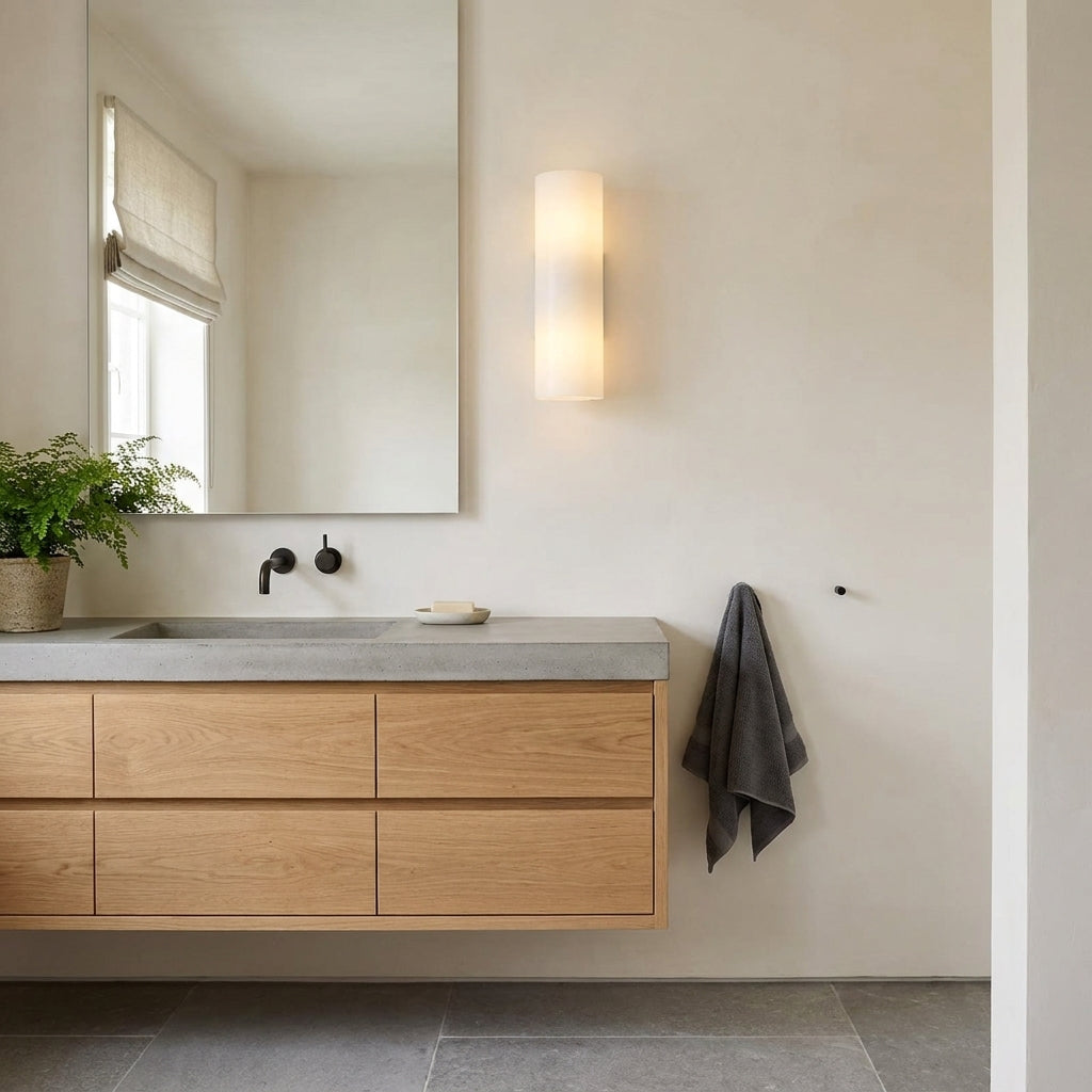 Ivzo black alabaster wall sconce mounted beside a bathroom vanity mirror
