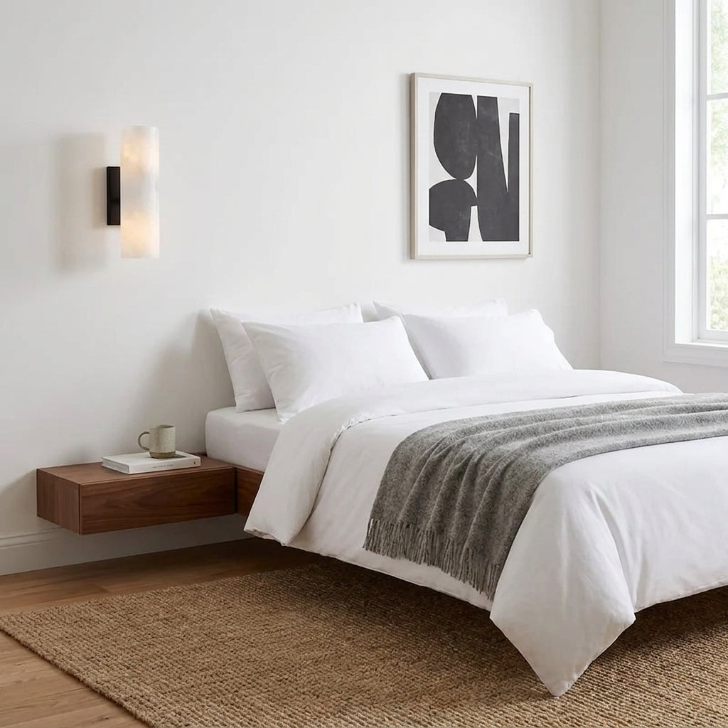 Ivzo black alabaster wall sconce beside a bed in a bedroom