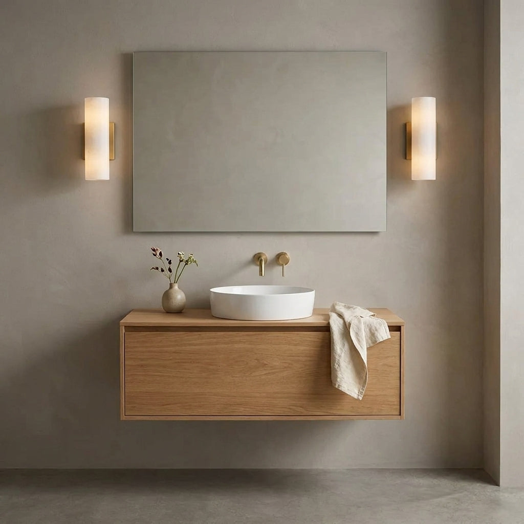 Ivzo brass alabaster wall sconce mounted beside a bathroom vanity mirror