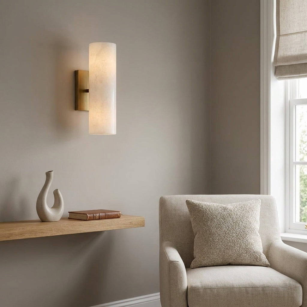 Ivzo brass alabaster wall sconce beside a living room armchair