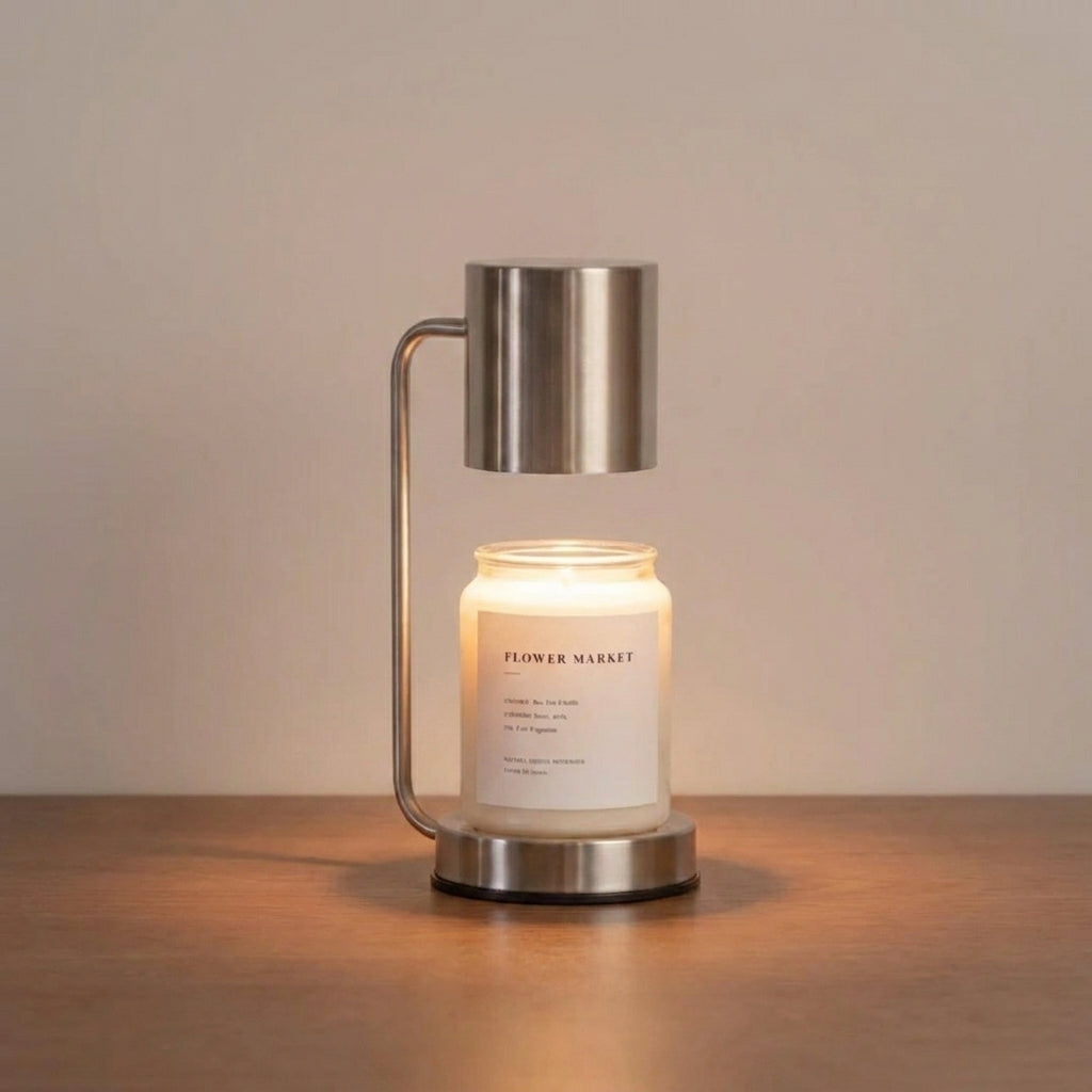 Jomzi stainless steel candle warmer lamp lit on a wooden table