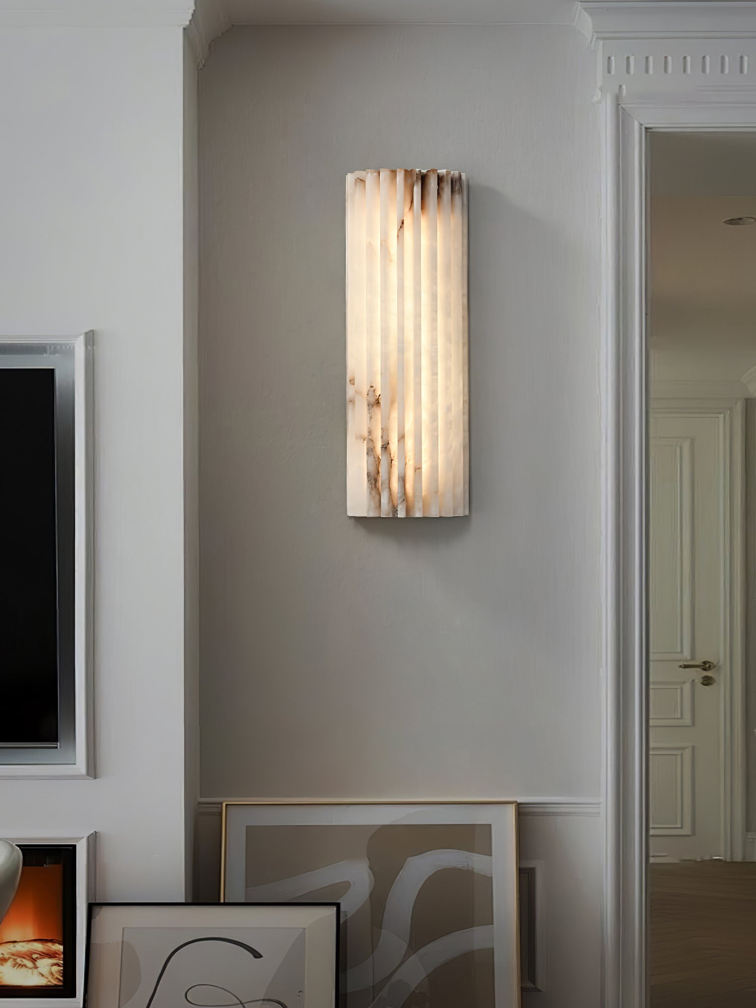 Modern ribbed marble jopna sconce illuminating a chic hallway space next to a doorway