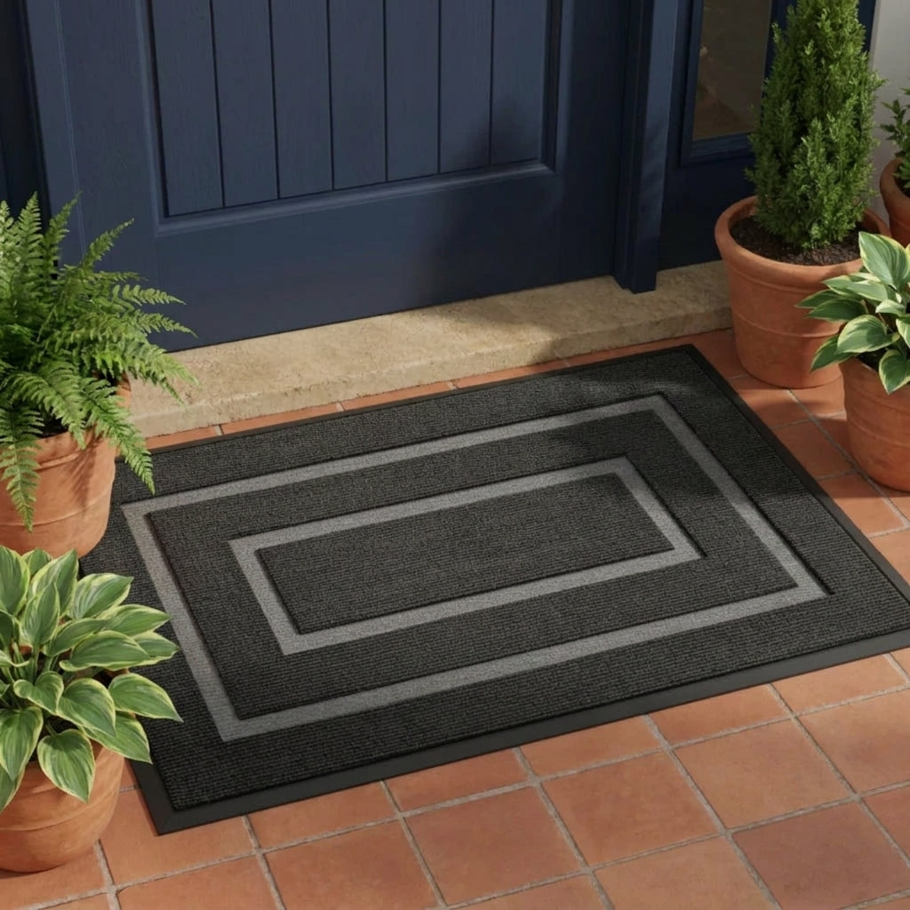 Kalzu black non-slip outdoor doormat in front of a blue front door with potted plants