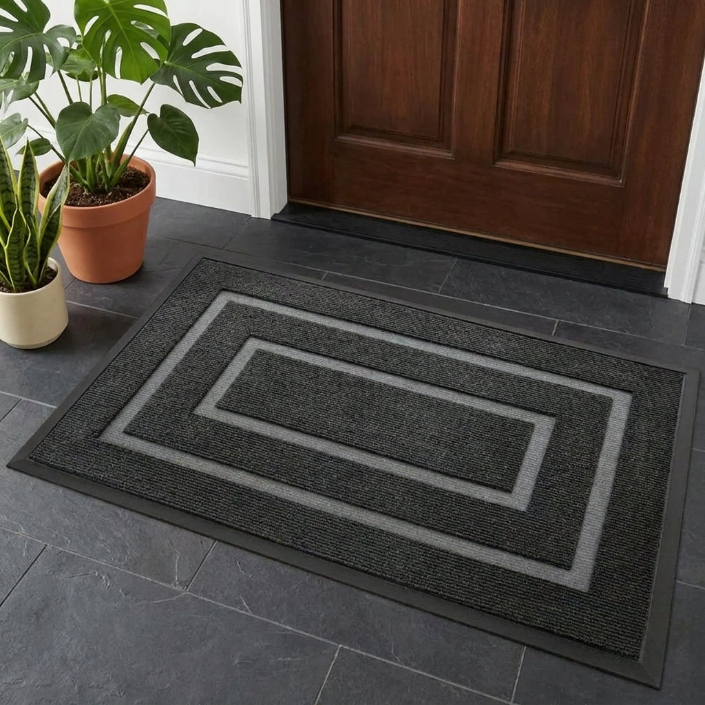 Kalzu black outdoor doormat in front of a wooden door on tile flooring