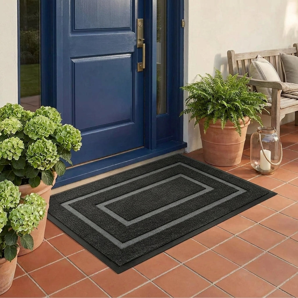 Kalzu black outdoor doormat in front of a blue door on terracotta floor tiles