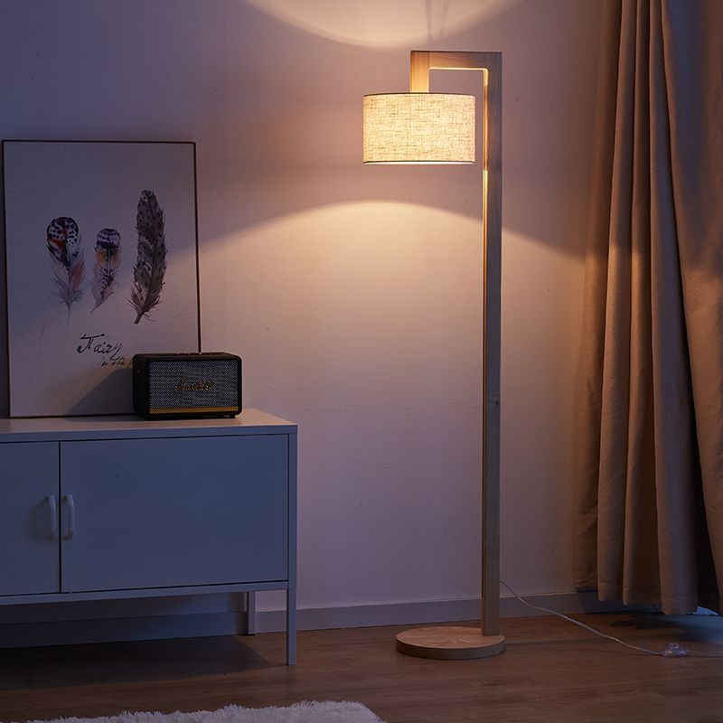 Overhanging wooden kelta floor light illuminating a living room corner next to a blue cabinet