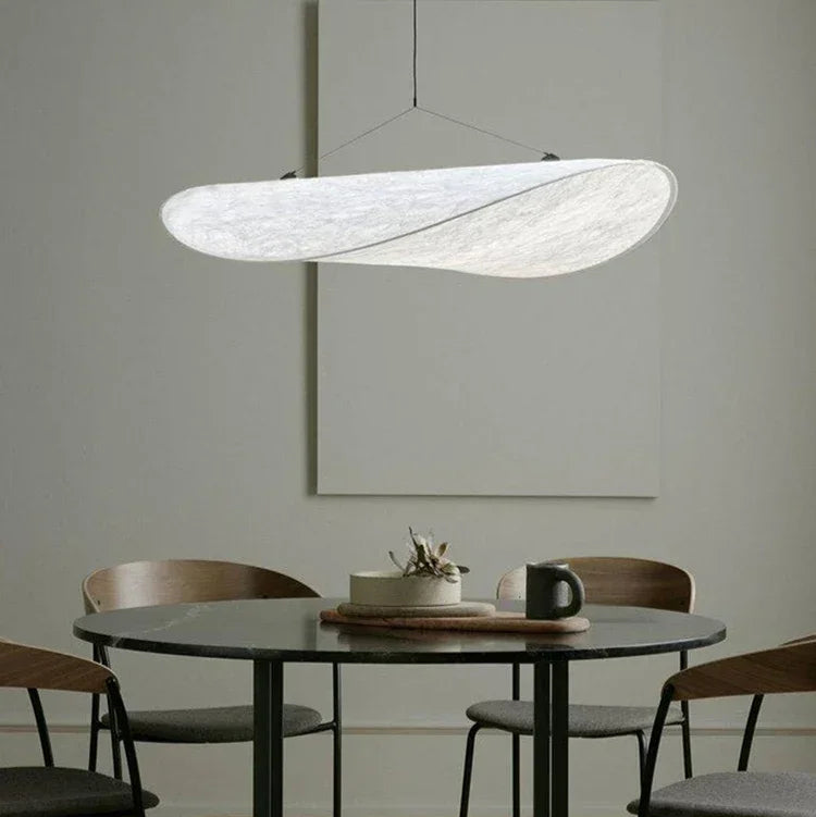 Minimalist silk wave hanging korta lamp providing a tranquil glow above a small round dining table