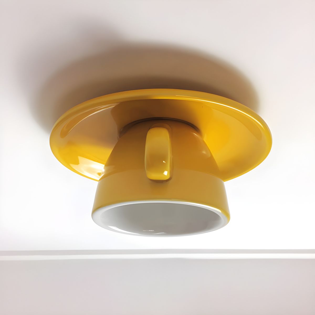 Bright yellow ceramic coffee cup flush mount kupce ceiling light installed on a white ceiling