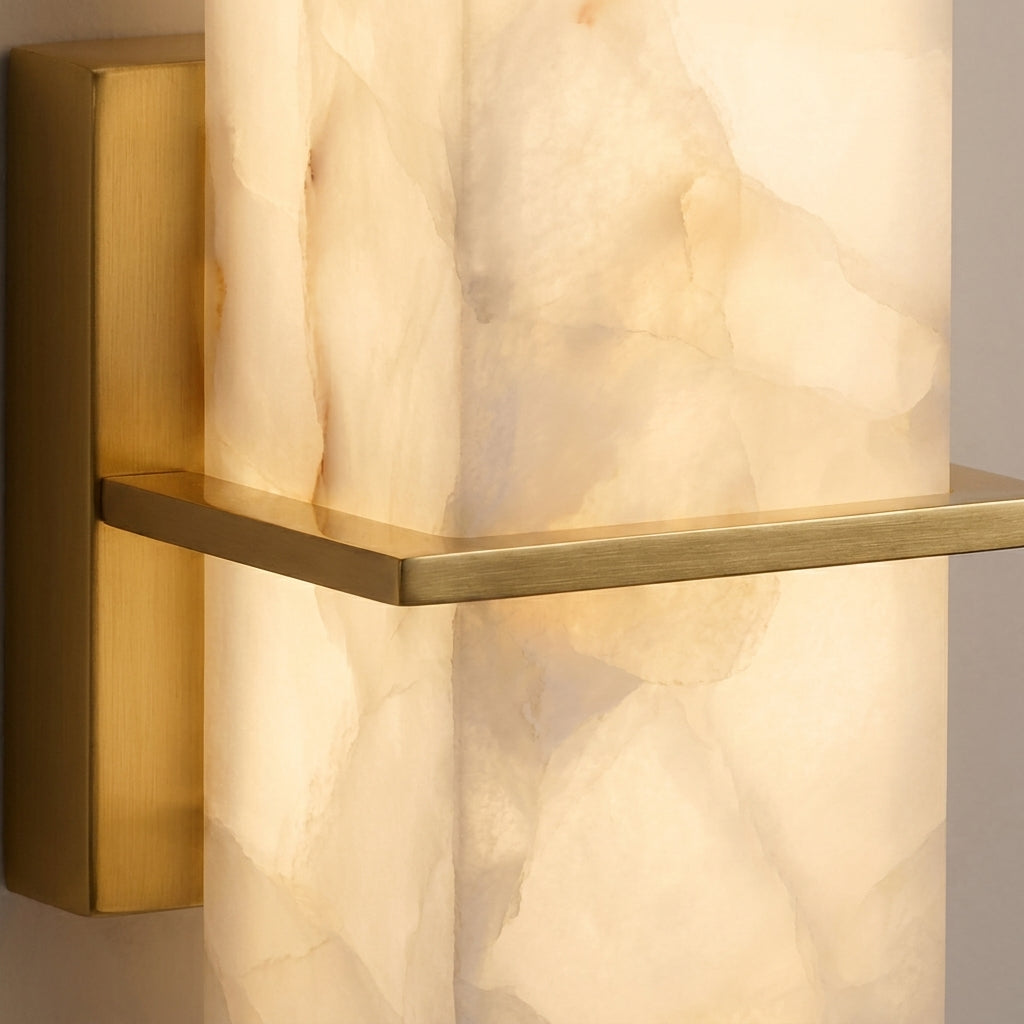 Close-up of the Kuvri wall lamp's gold metal bracket and alabaster texture