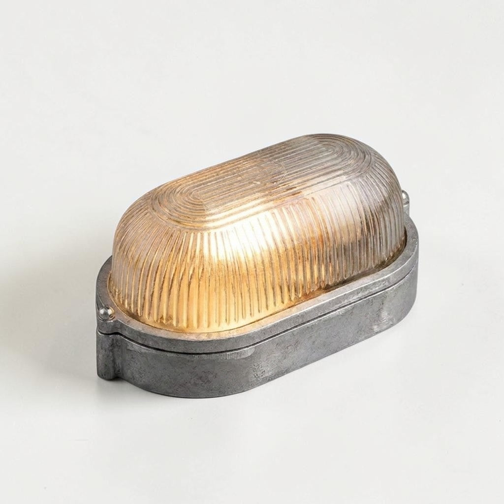 Kuxqa bulkhead wall light in Compact Shield style, on a grey studio background