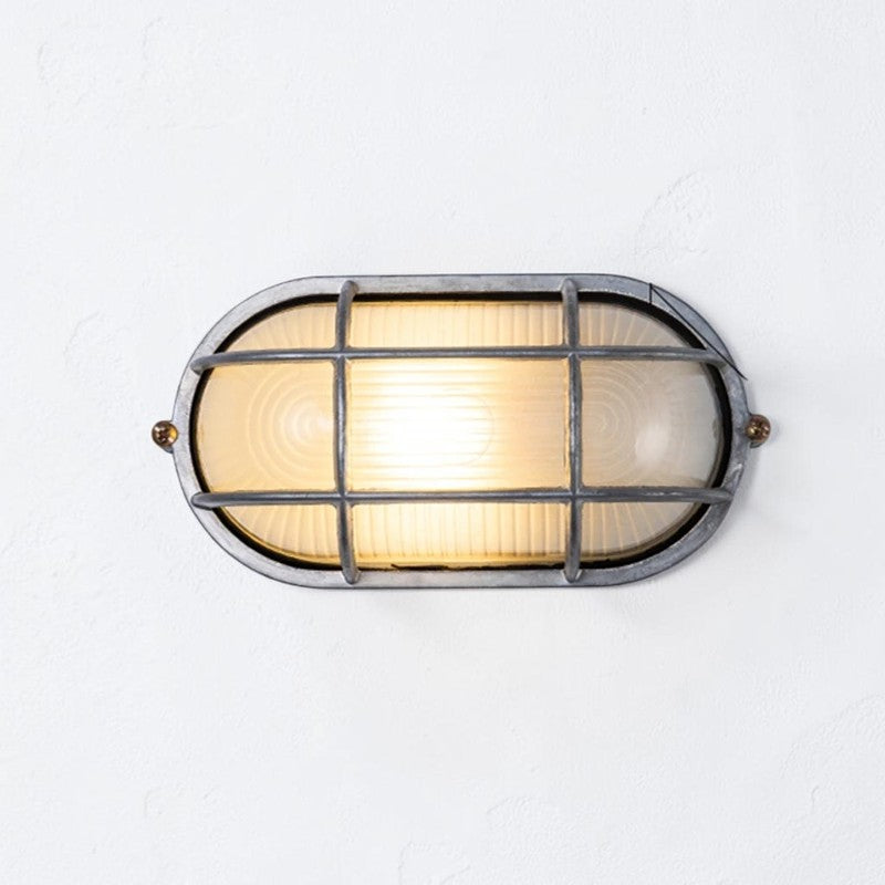 Kuxqa bulkhead wall light in Grid Cage style, large size, illuminated, on a grey studio background