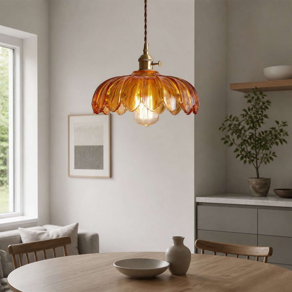 Kyler amber ribbed glass pendant light hanging in a dining nook with a potted plant on an open shelf