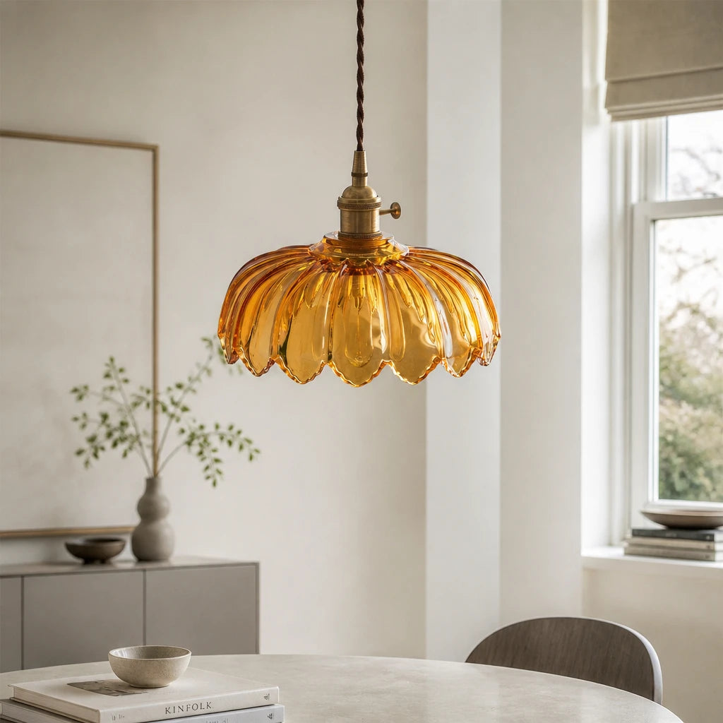 Kyler amber ribbed glass pendant light hanging above a dining table with a sideboard and vases