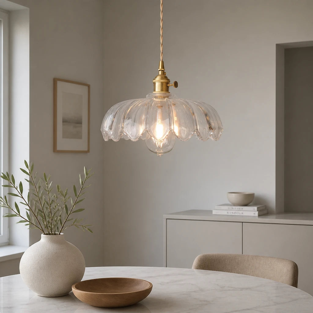 Kyler clear ribbed glass pendant light hanging above a round marble dining table with a vase