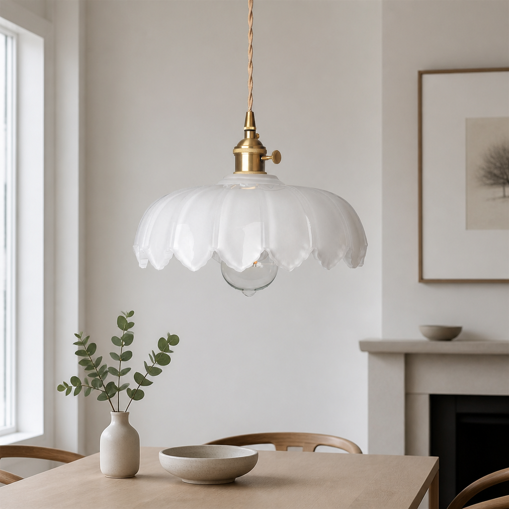 Kyler white ribbed glass pendant light hanging above a dining table with eucalyptus in a vase