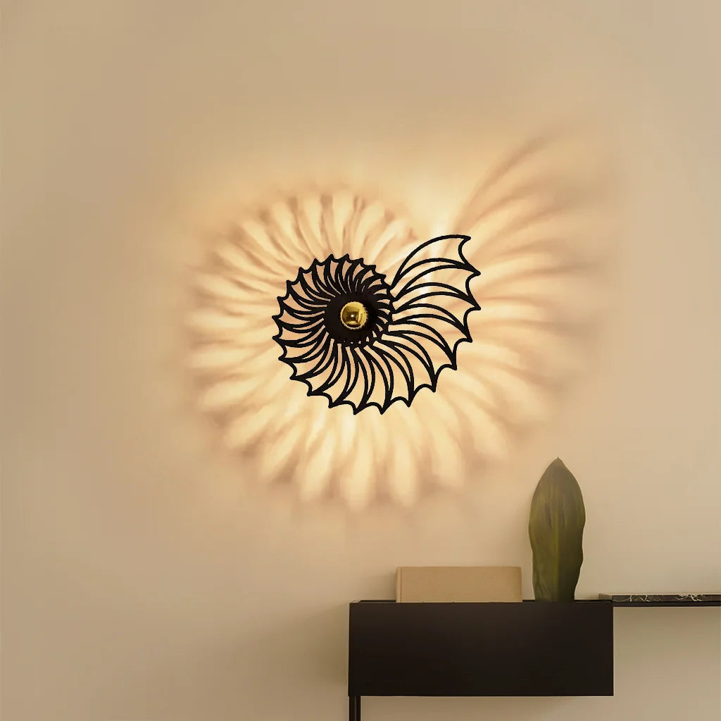 Large black Nautilus wall fixture providing a warm, intricate ambient glow