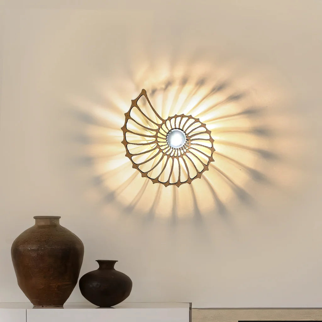 Large gold spiral accent sconce highlighting its precision-cut metal design and glowing shadow effect