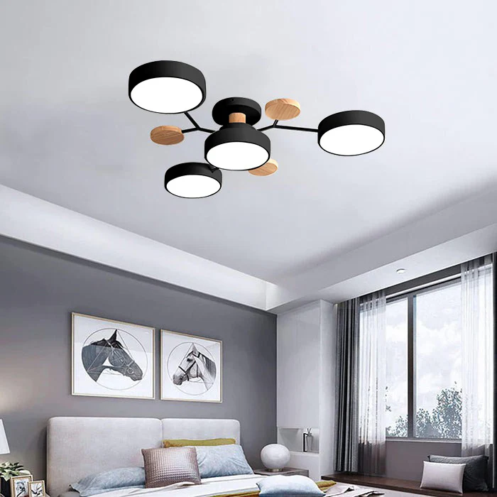 Modern lasve black 4-light Nordic branch ceiling lamp with wood accents illuminating a contemporary bedroom.