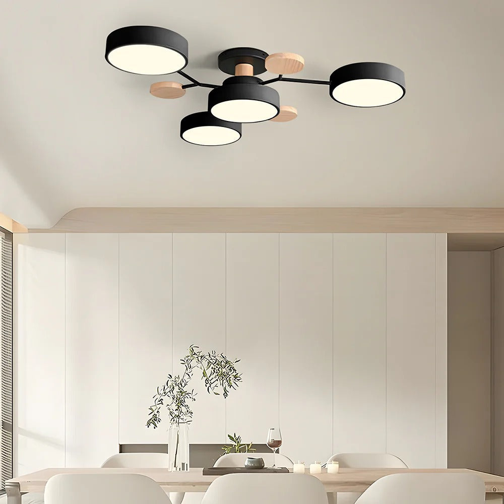 Black 4-light Nordic branch lasve chandelier suspended over a modern dining room table