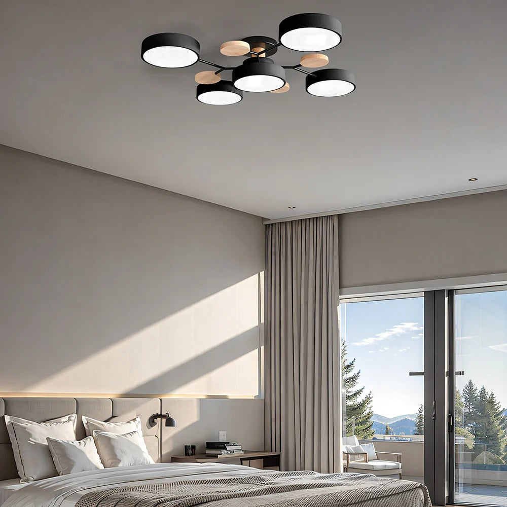 Expansive lasve black 5-light modern branch ceiling lamp casting a warm glow over a large bed