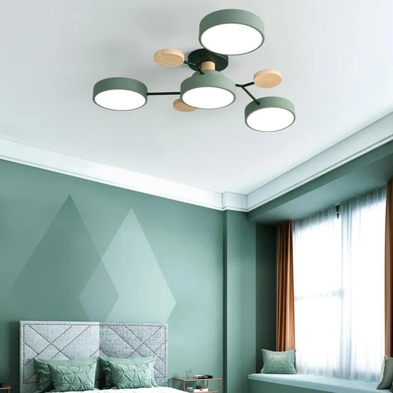 Compact lasve green 4-light wood and metal ceiling fixture adding subtle charm to a bedroom with green walls