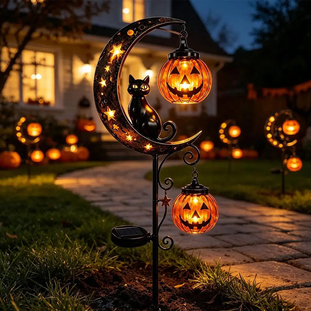 Lawnlurk solar black cat and pumpkin moon stake lights glowing along a garden pathway at night