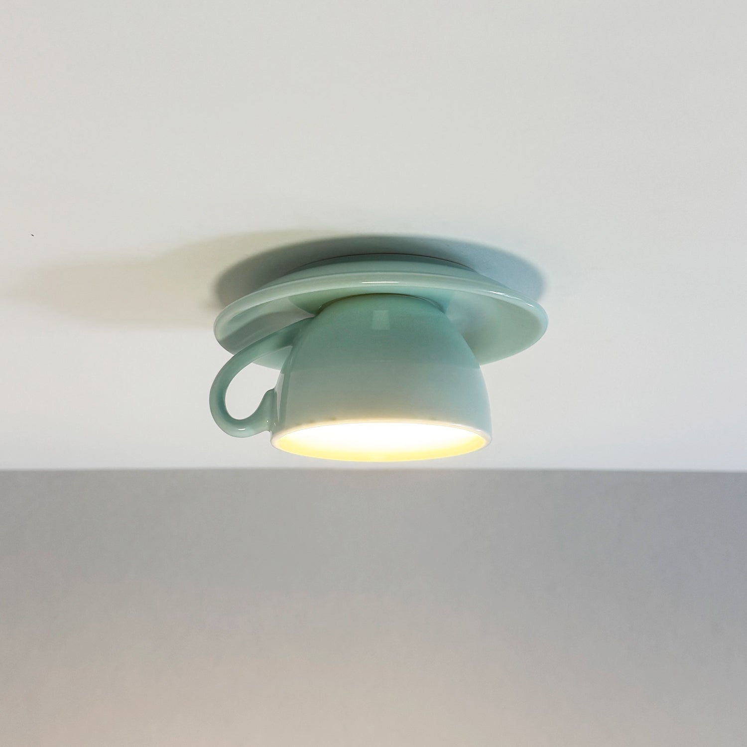 Light blue ceramic teacup ceiling lamp providing soft ambient illumination