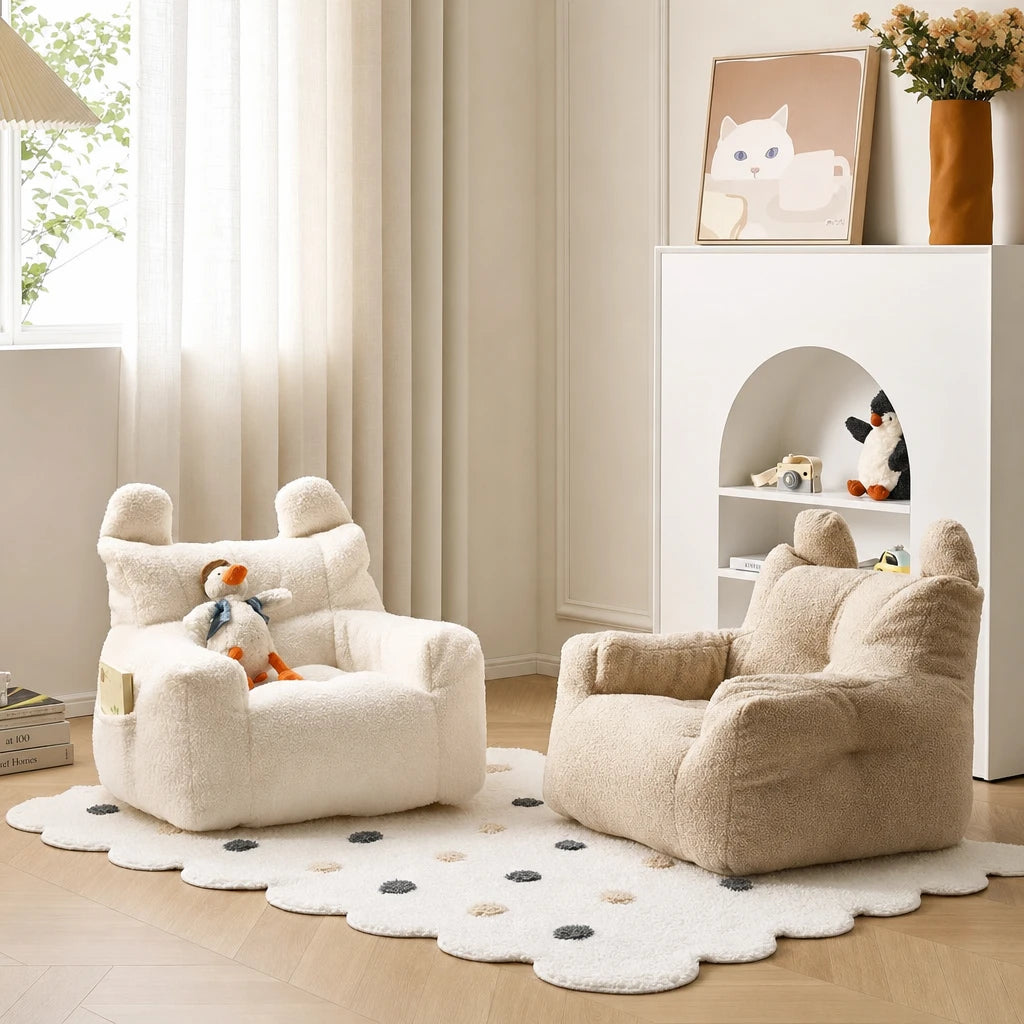 Cream and beige Lydel kids armchairs beside a white shelving console with cat artwork and fresh flowers in a minimalist room