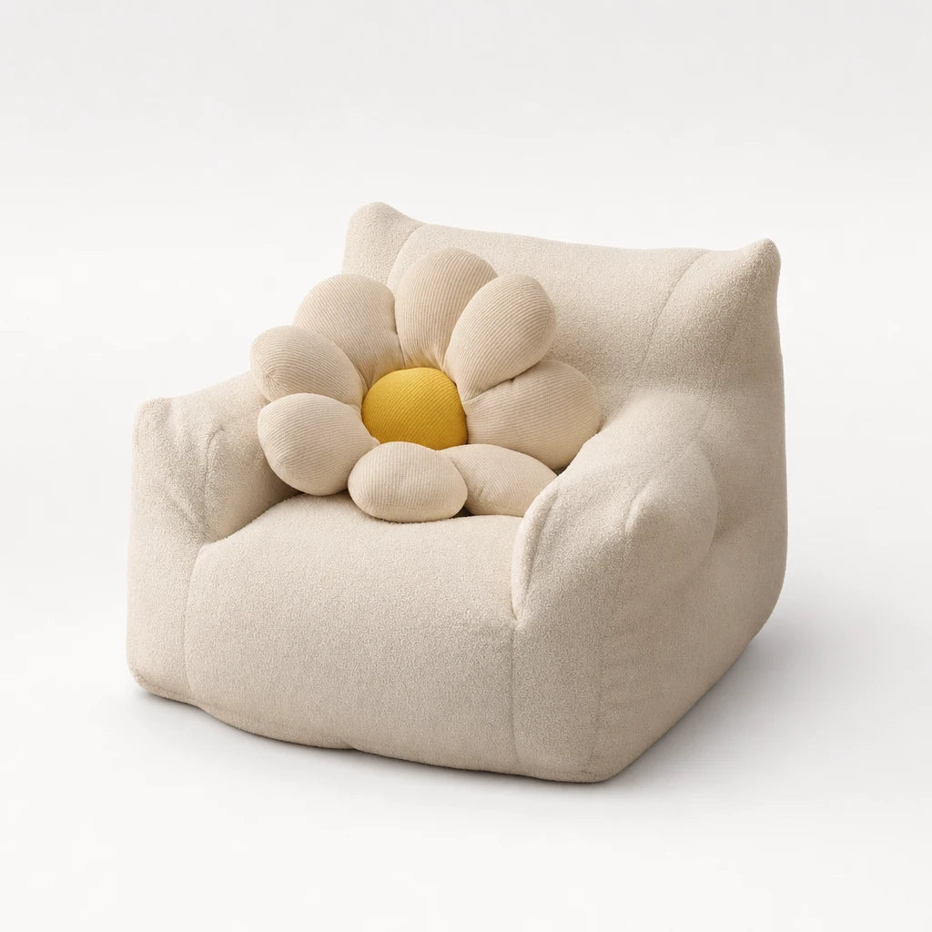 Cream Lydel kids bean bag armchair on a studio background styled with a decorative flower-shaped cushion