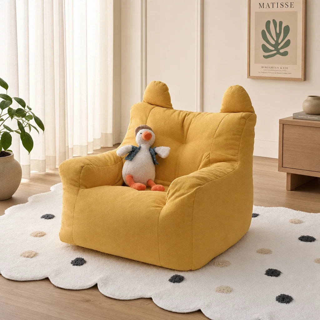 Yellow Fleece Lydel cartoon bear kids bean bag armchair with a duck plush toy in a modern minimalist room