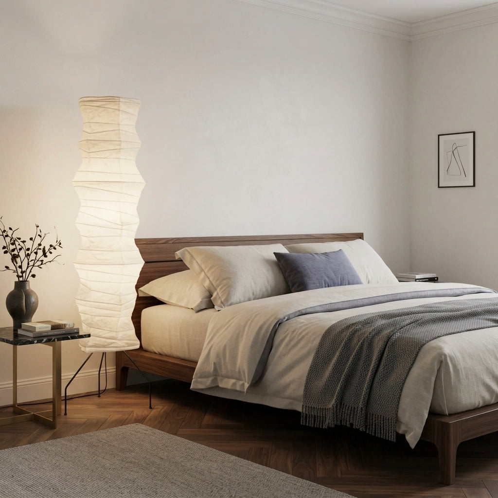 Mepzo floor lamp beside a bed in a bedroom with a small nightstand and vase