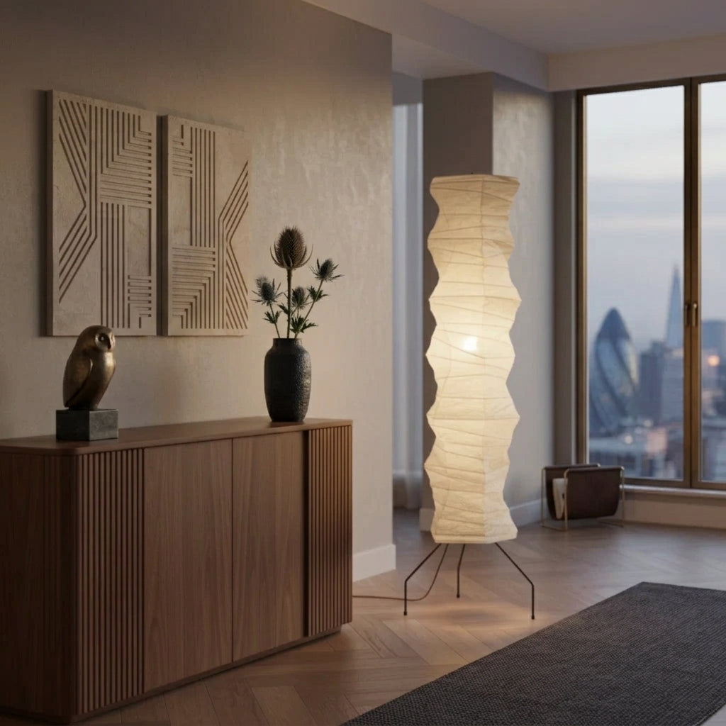 Mepzo rice paper floor lamp in a modern living room with wall art, a vase, and a city skyline view at dusk
