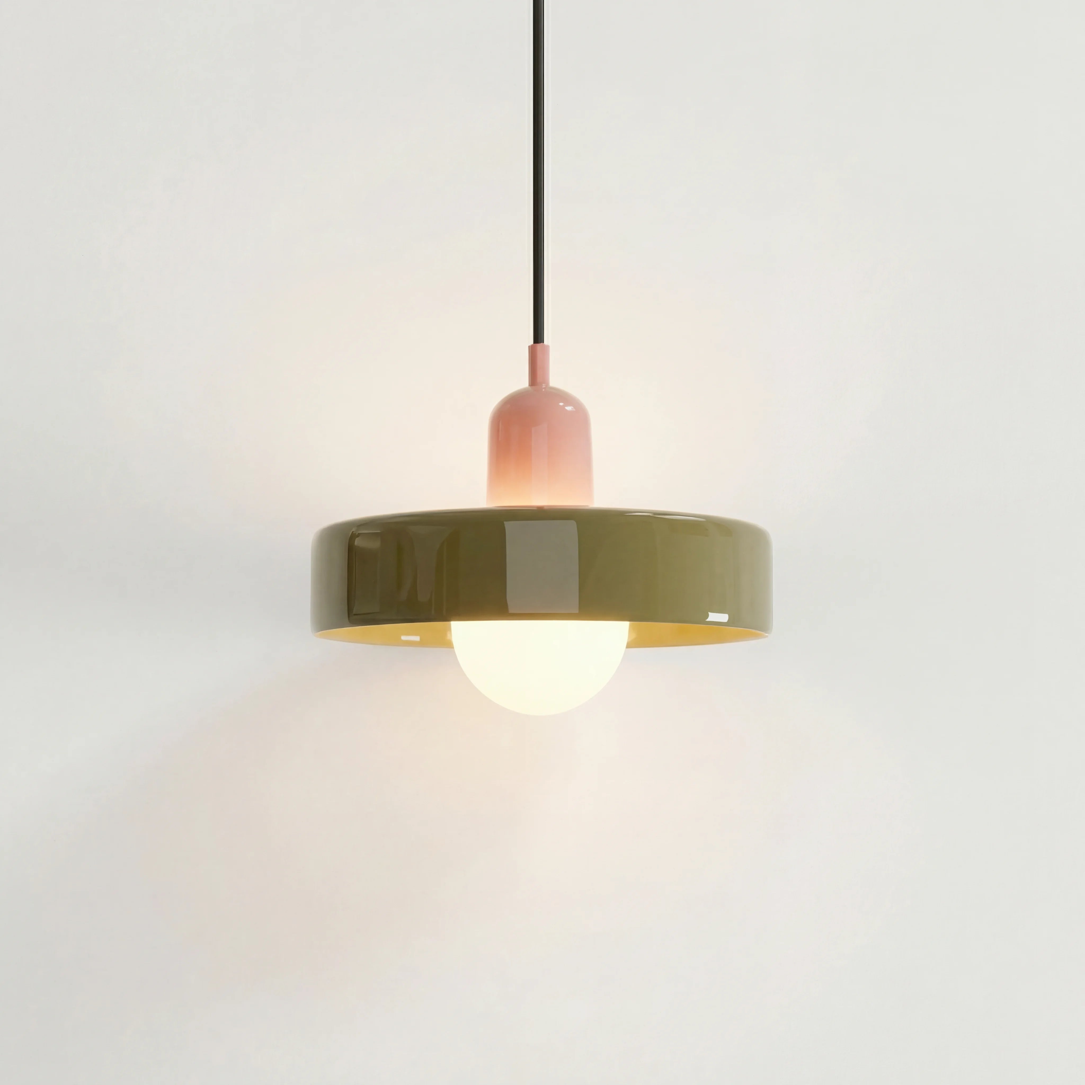 Pink and green mid-century mera pendant light suspended elegantly against a white wall
