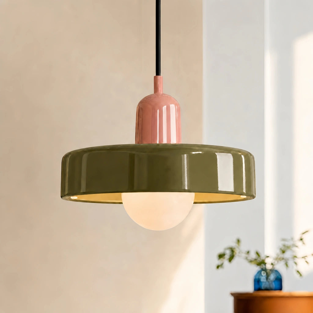 Pink and green mera mid-century pendant glowing softly in a warm, sunlit interior