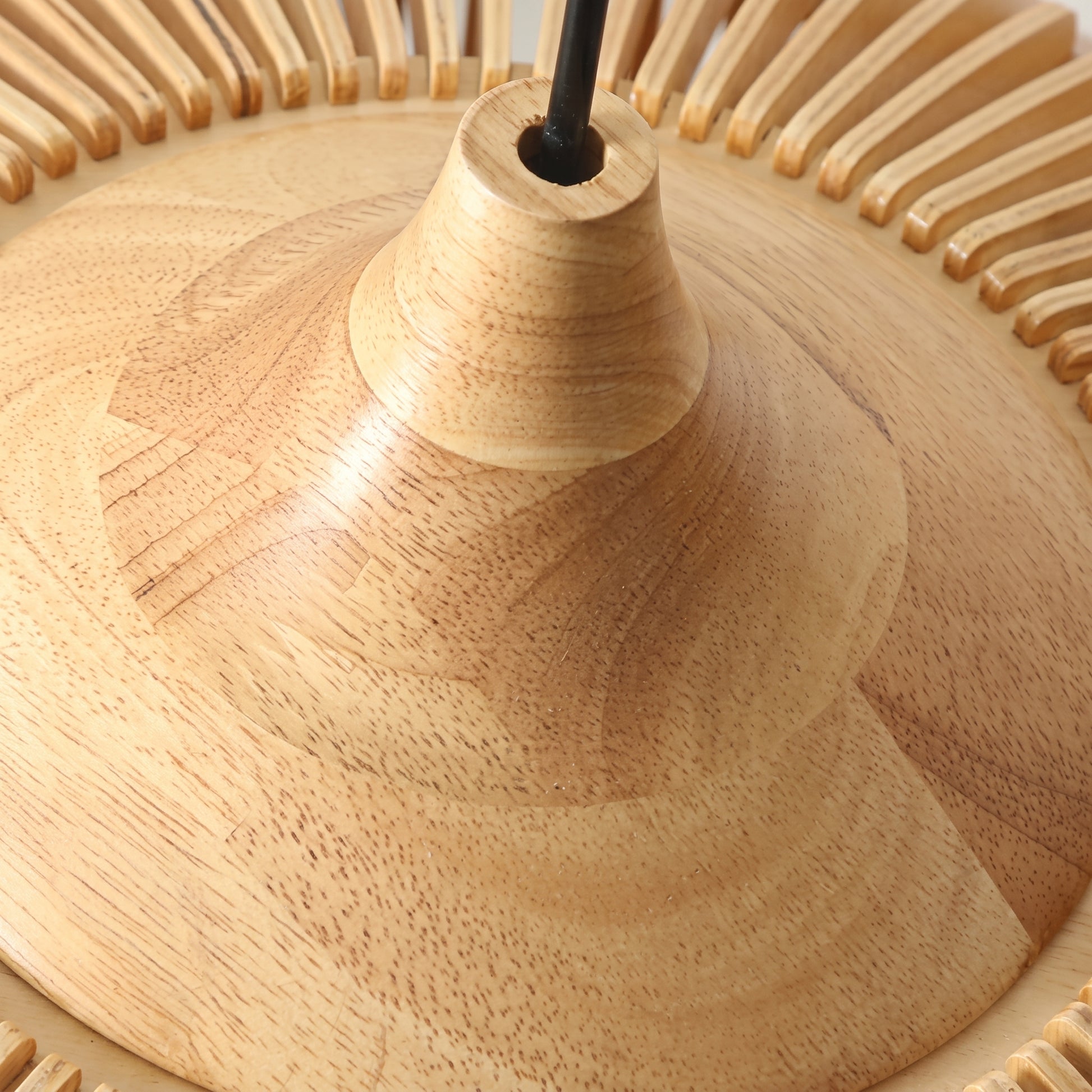 A close-up detail of the Modern Japandi slatted wood mexi pendant light in a natural finish, focusing on the smooth, turned wood top section where the black suspension cable connects
