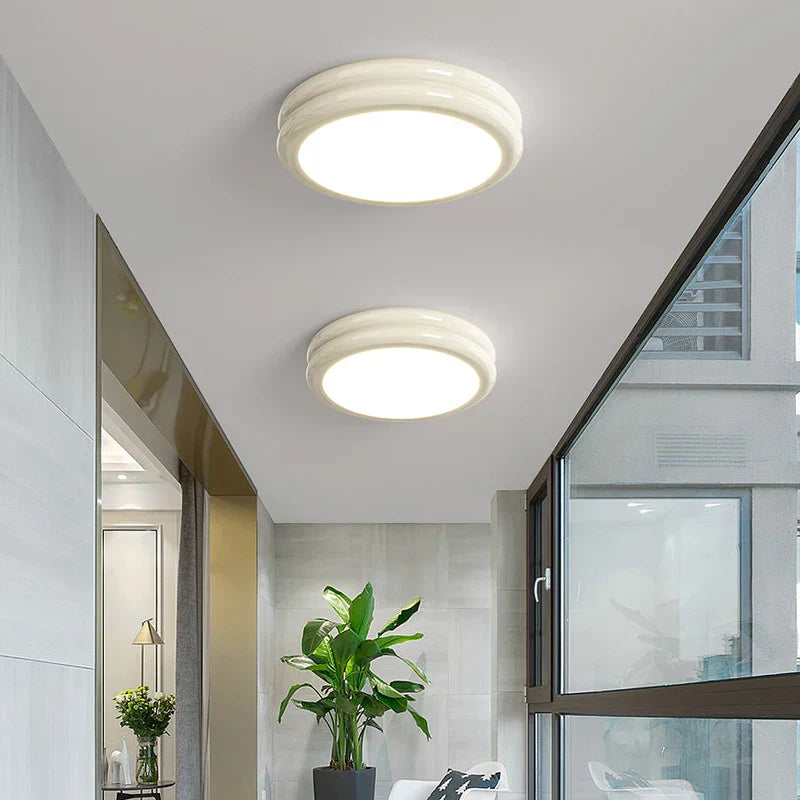 Milky white minimalist flush mount ceiling lights glowing warmly in a contemporary living space