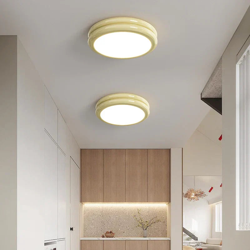 Pair of milky yellow macaron ceiling lights illuminating a bright, modern kitchen space