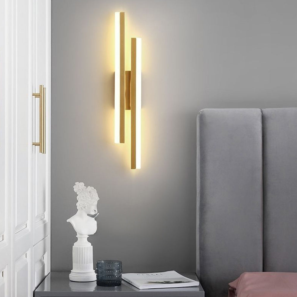Elegant milor gold staggered linear wall sconce mounted as a luxurious accent light in a contemporary bedroom