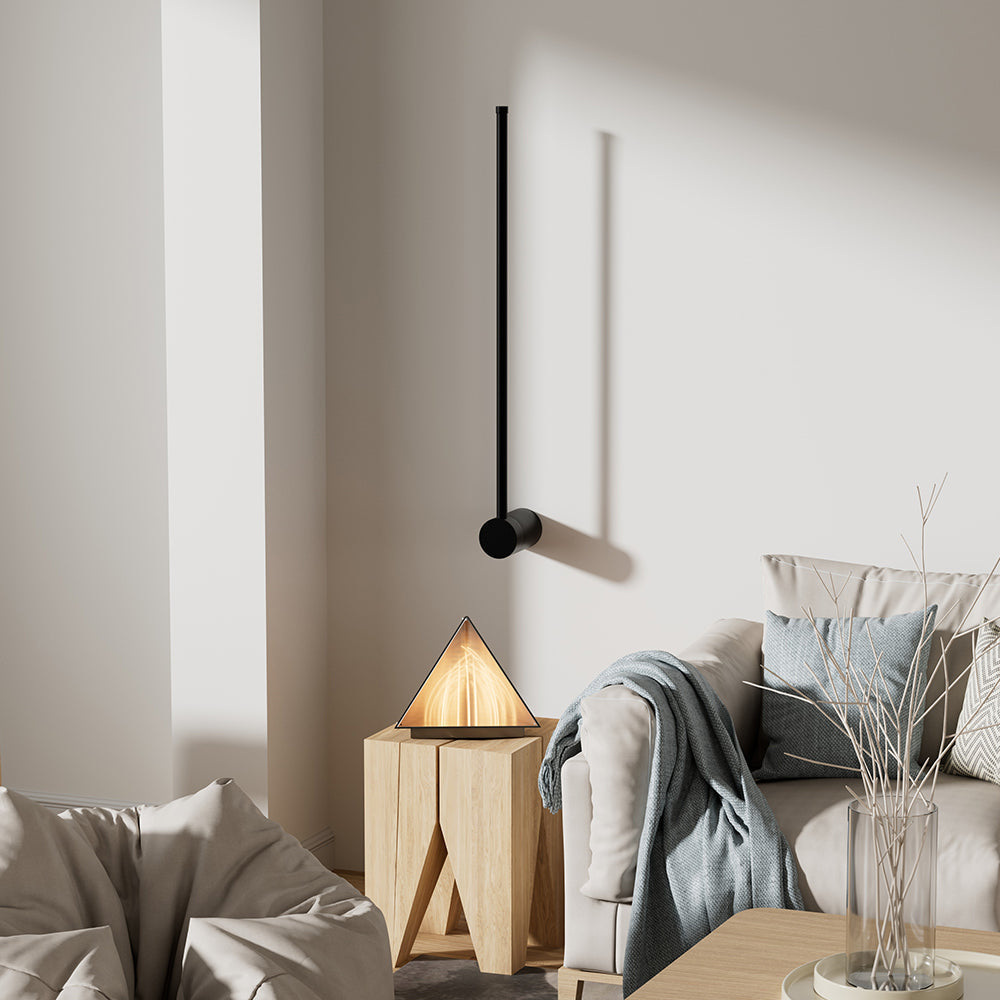 Minimalist black linear wall lamp acting as an elegant living room accent sconce in a cosy corner