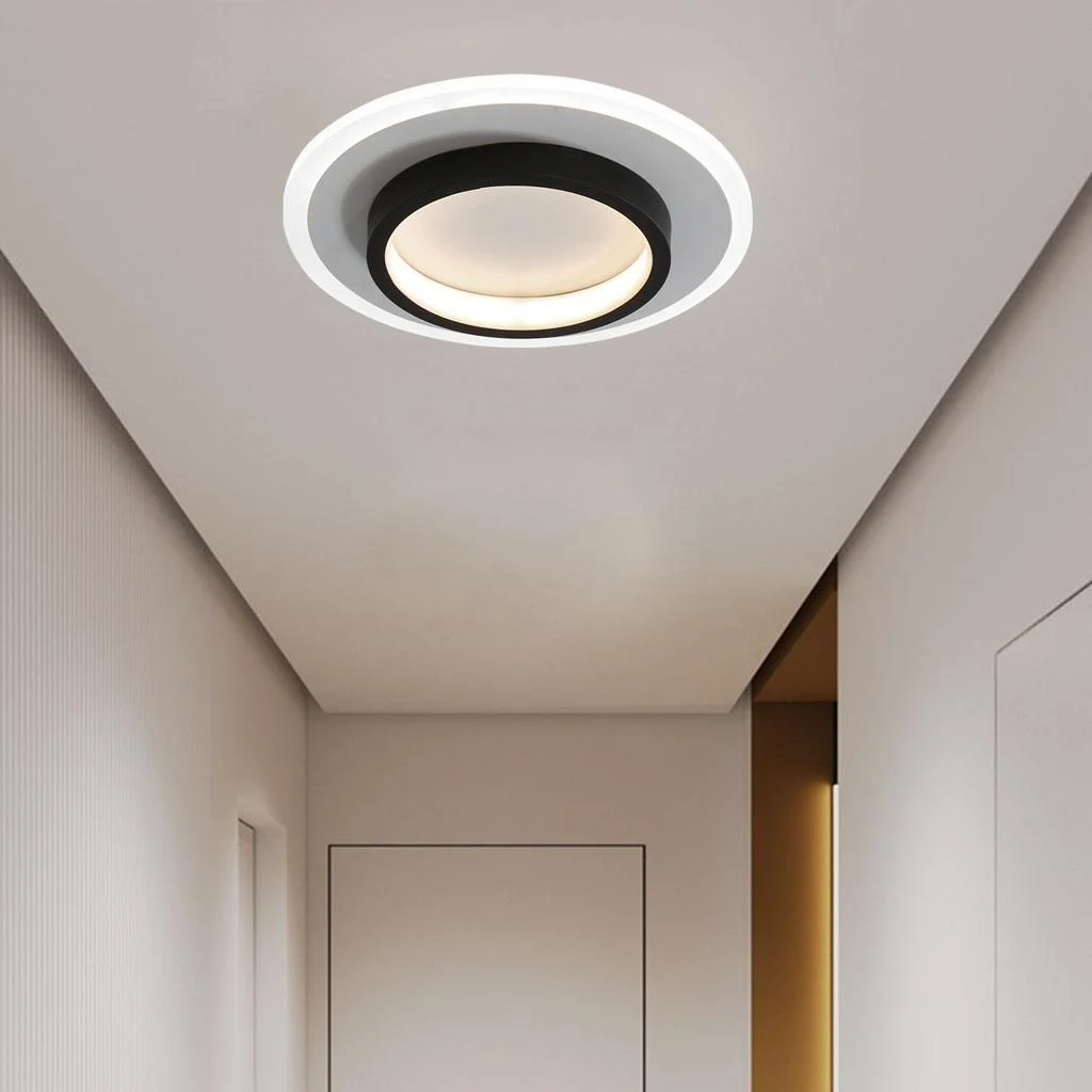 Single minimalist black double-ring flush mount ceiling light in a bright white hallway