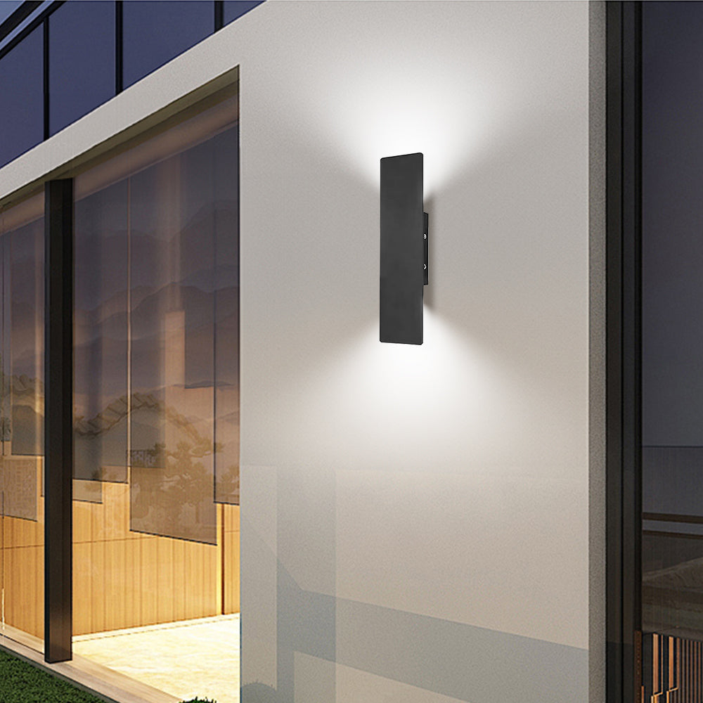 Minimalist black exterior wall sconce providing warm up and down lighting