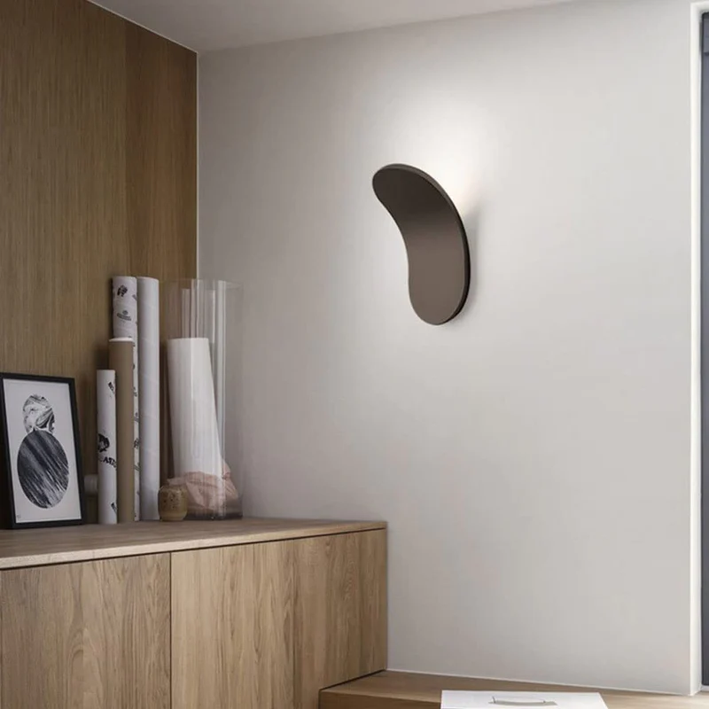 Minimalist brown wall light illuminating a modern space with wooden cabinetry