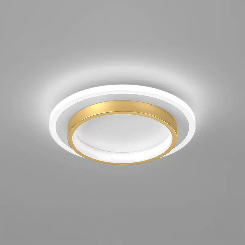 Minimalist gold double-ring LED ceiling fixture glowing against a grey background