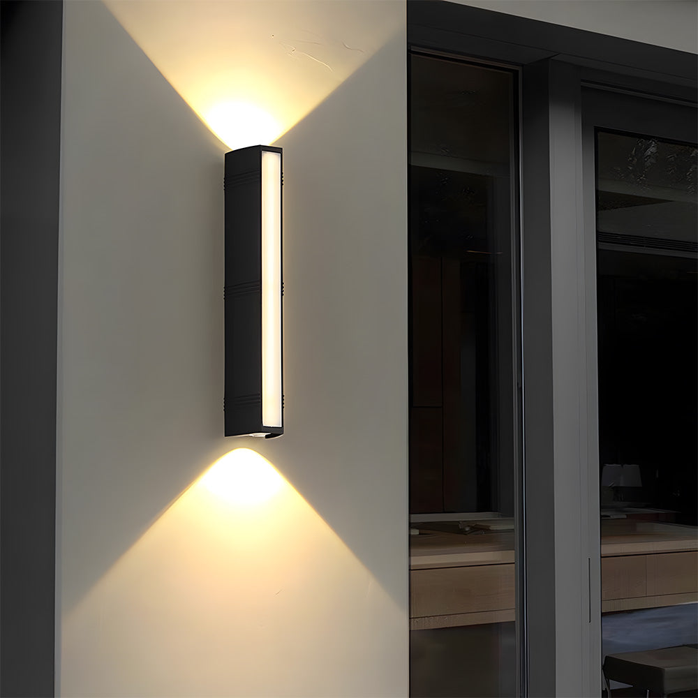 Minimalist black outdoor sconce acting as elegant accent lighting next to a large dark window