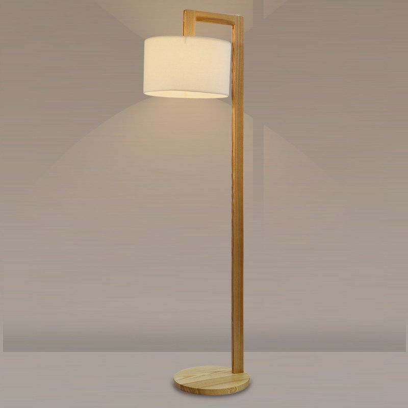 Illuminated minimalist wood floor lamp highlighting its clean architectural lines and warm light