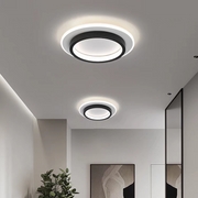 Two modern black geometric halo LED flush mount ceiling lights illuminating a contemporary hallway
