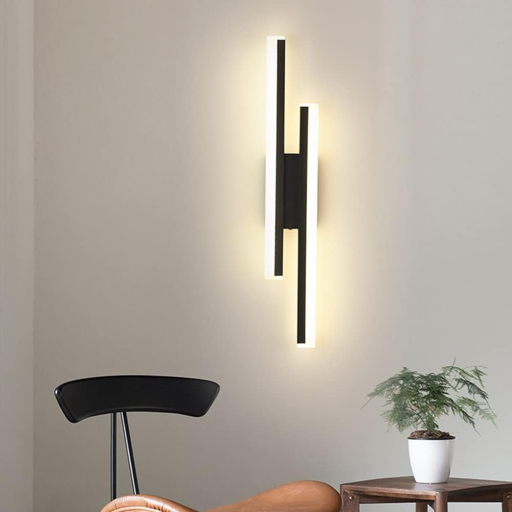 Sleek modern black LED wall fixture with glowing acrylic bars casting a warm light against a plain wall